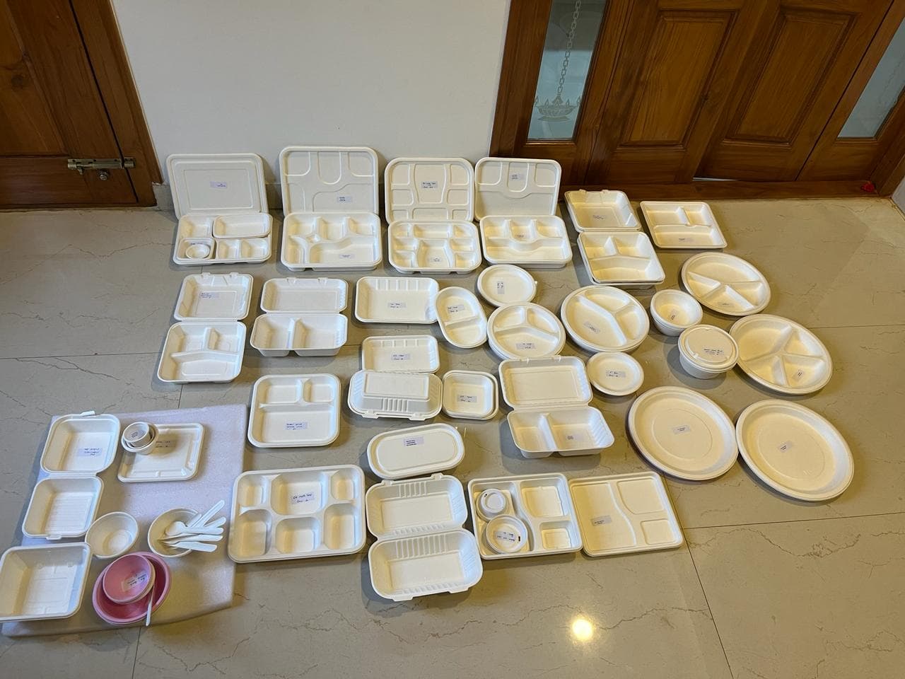 Bagasse plates, cups and wooden cutlery on white background