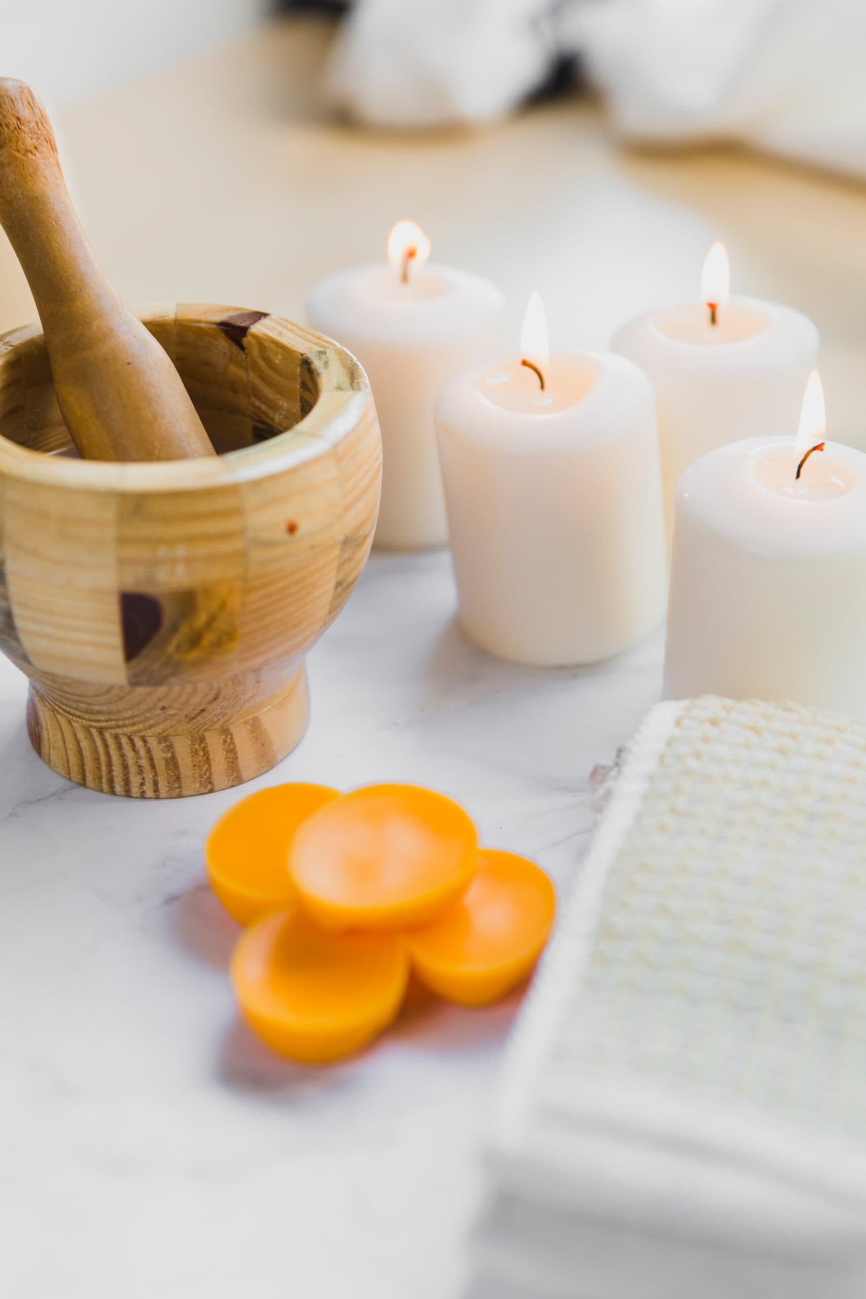 Purple candles in a wicker bowl with white pebbles
